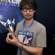 Hideo Kojima poses with a model of a futuristic space ship.